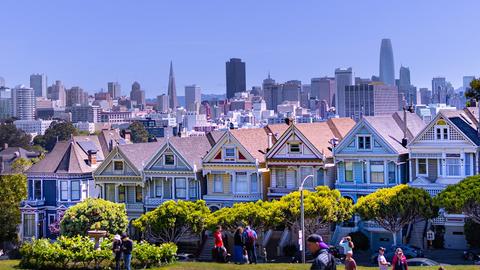 a group of people standing in front of a row of houses
