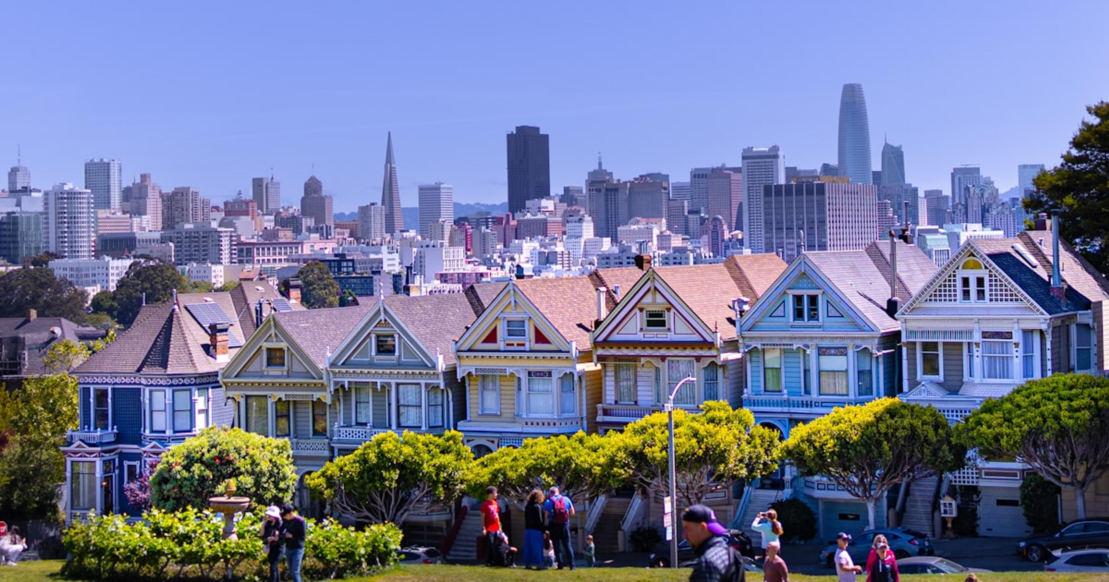 a group of people standing in front of a row of houses