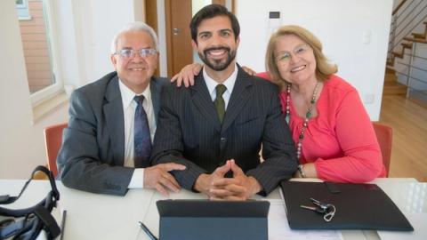 Group of business professionals smiling inside office setting, showcasing teamwork and real estate partnership.