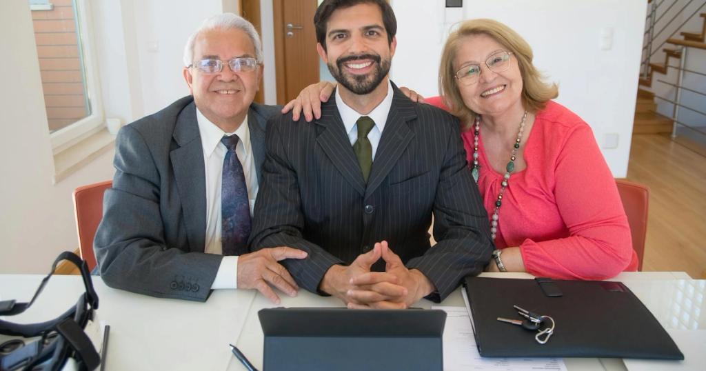 Group of business professionals smiling inside office setting, showcasing teamwork and real estate partnership.