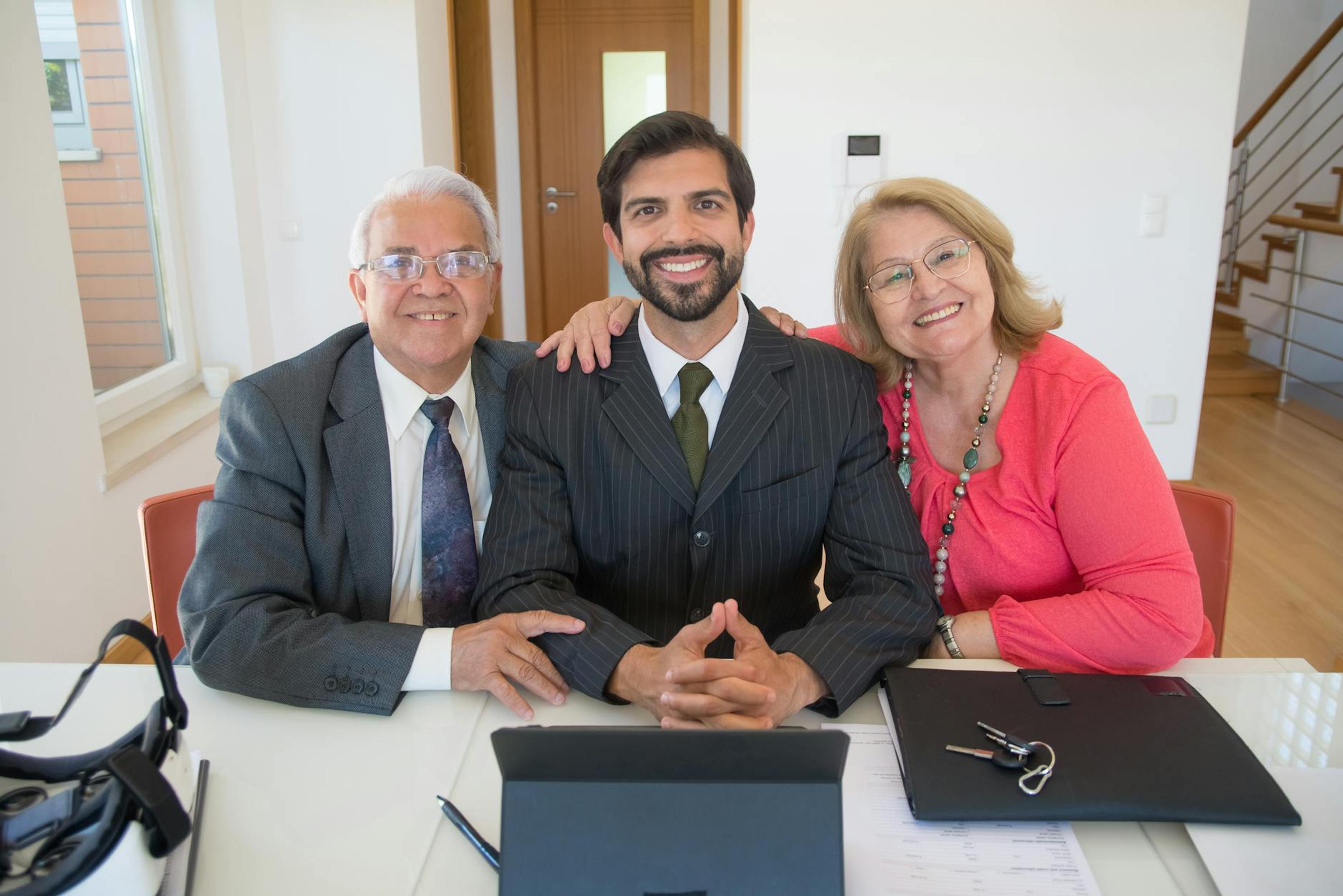 Group of business professionals smiling inside office setting, showcasing teamwork and real estate partnership.