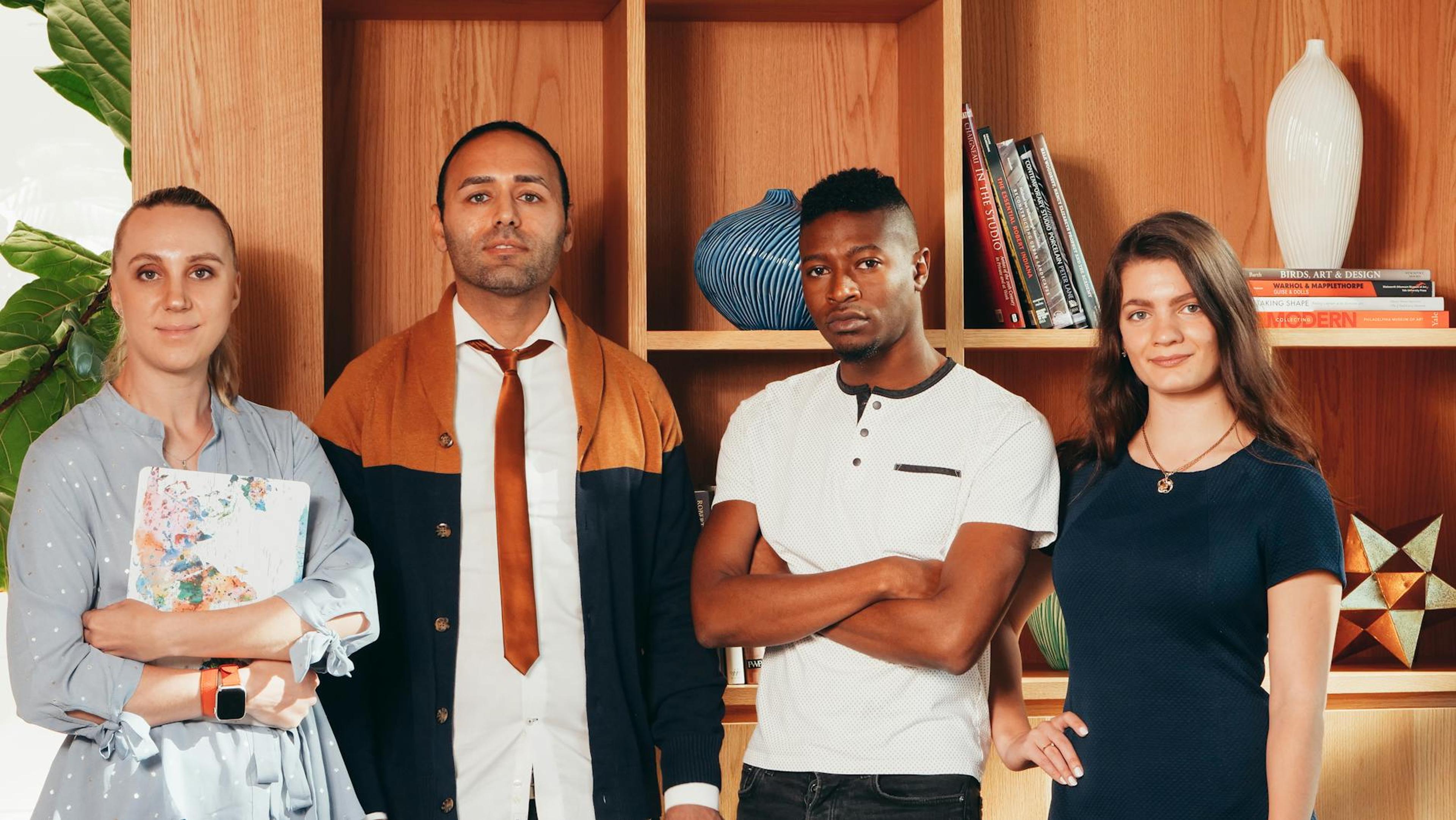 A diverse group of professionals posing confidently together in an office setting with bookshelves.