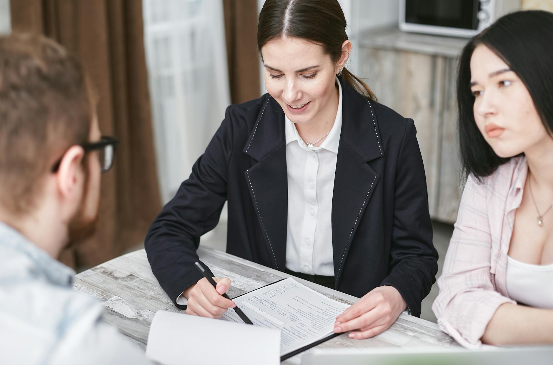A business meeting with a diverse team indoors, discussing documents and investments.