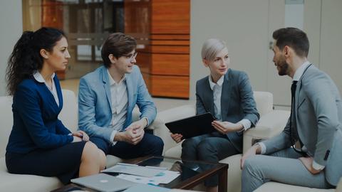 Four business people in a meeting discussing documents.