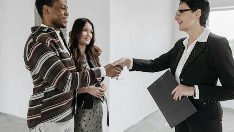 Business professionals shake hands in a modern office, symbolizing a successful deal.