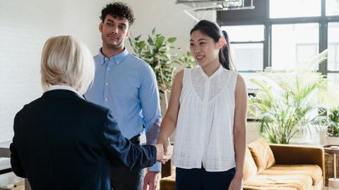 A young couple meeting with a real estate agent in a modern apartment setting.
