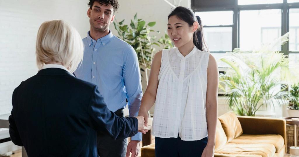 A young couple meeting with a real estate agent in a modern apartment setting.