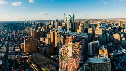 From above of modern district in city with high rise buildings under blue sky in sunny day