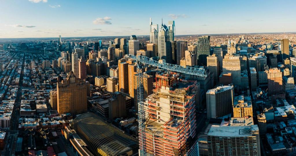 From above of modern district in city with high rise buildings under blue sky in sunny day