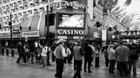 Black and white scene of people on Fremont Street near a casino.