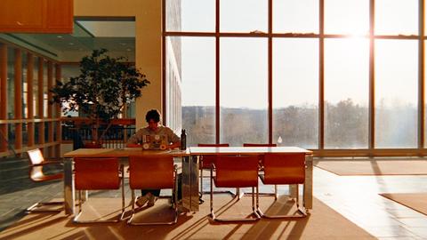 Person sitting at desk by large window