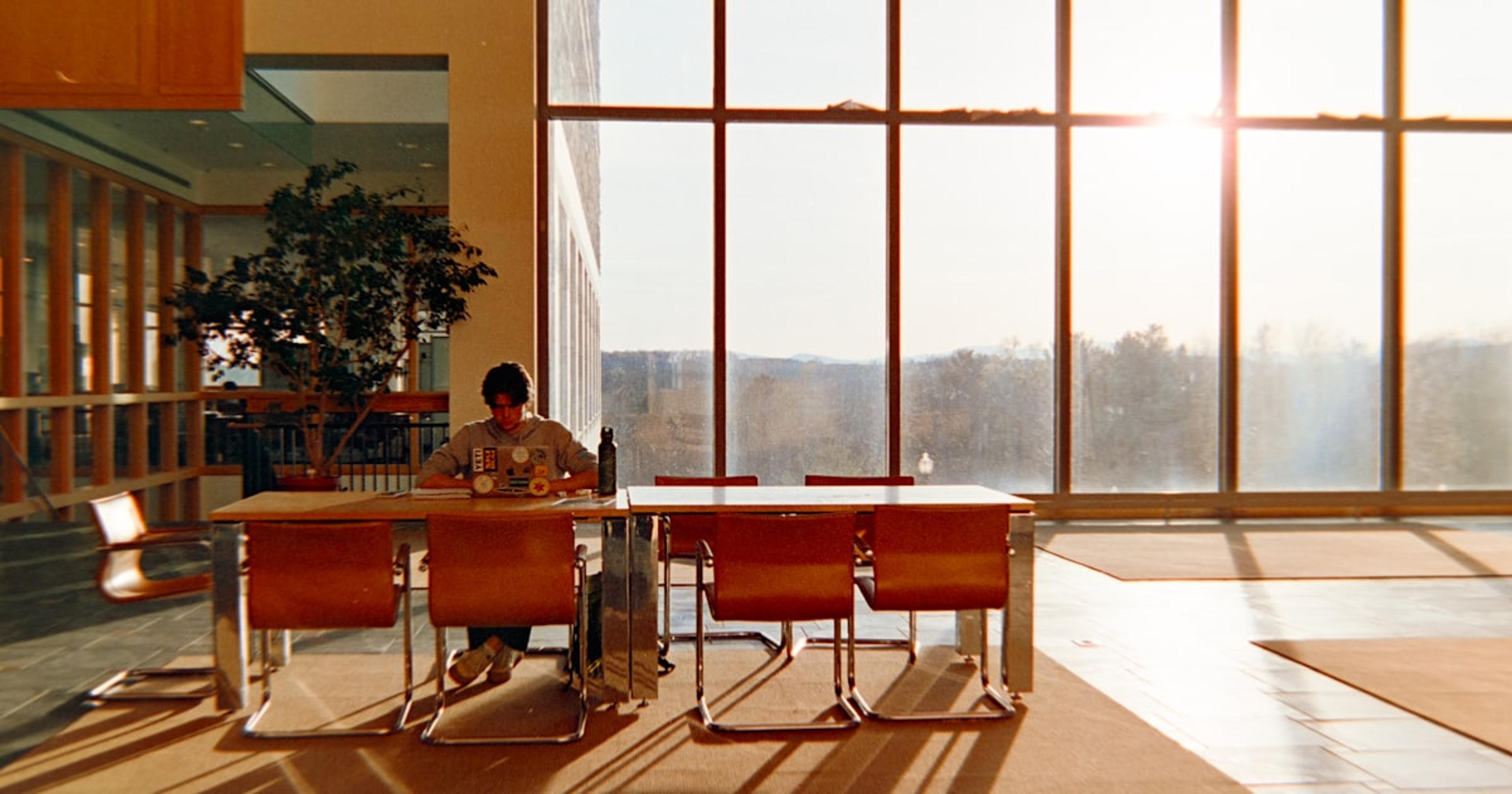 Person sitting at desk by large window