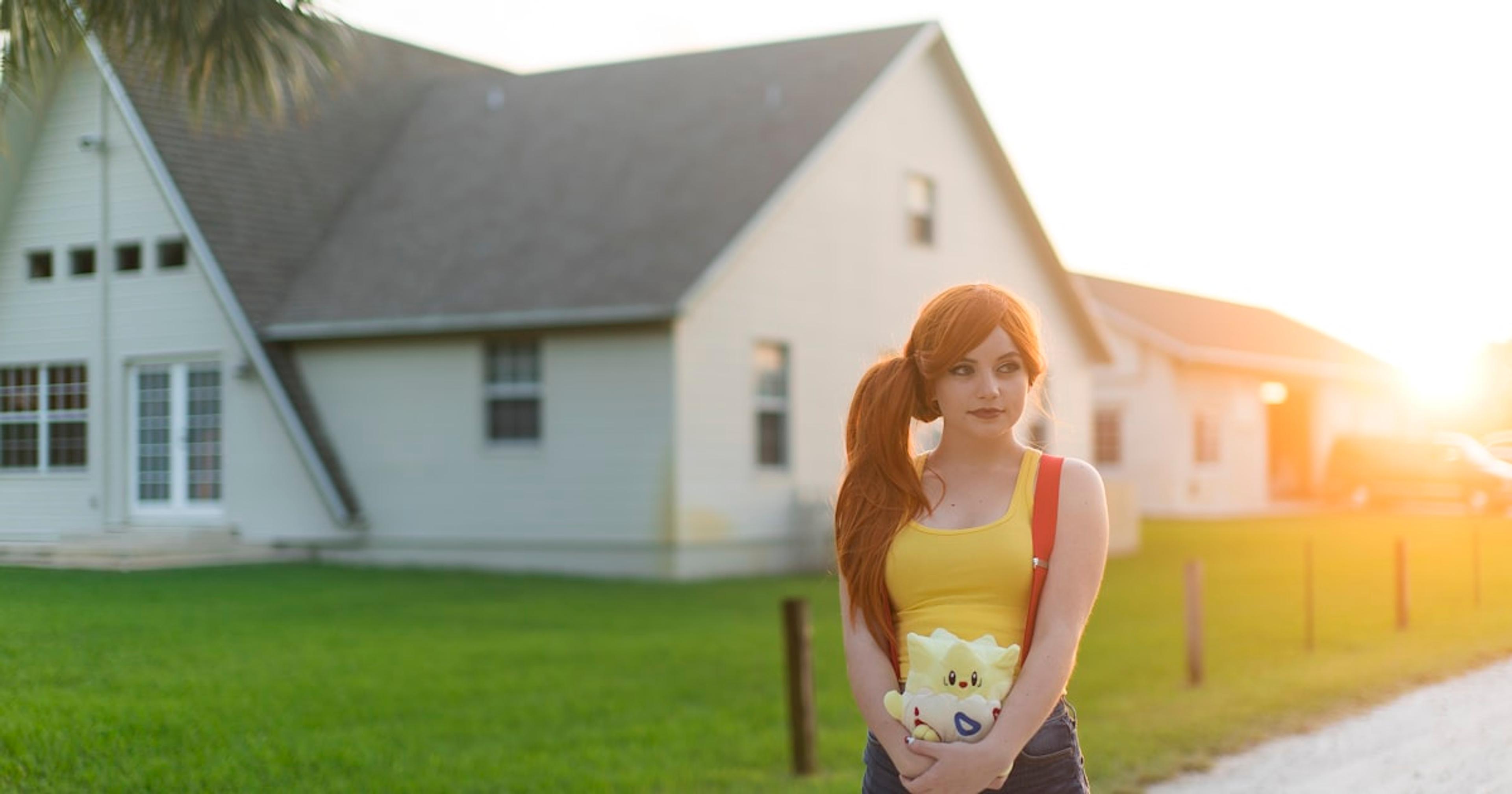 woman standing near white house during daytime