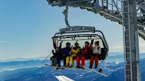 Group of skiers on a chairlift enjoying the winter scenery in Gudauri, Georgia.
