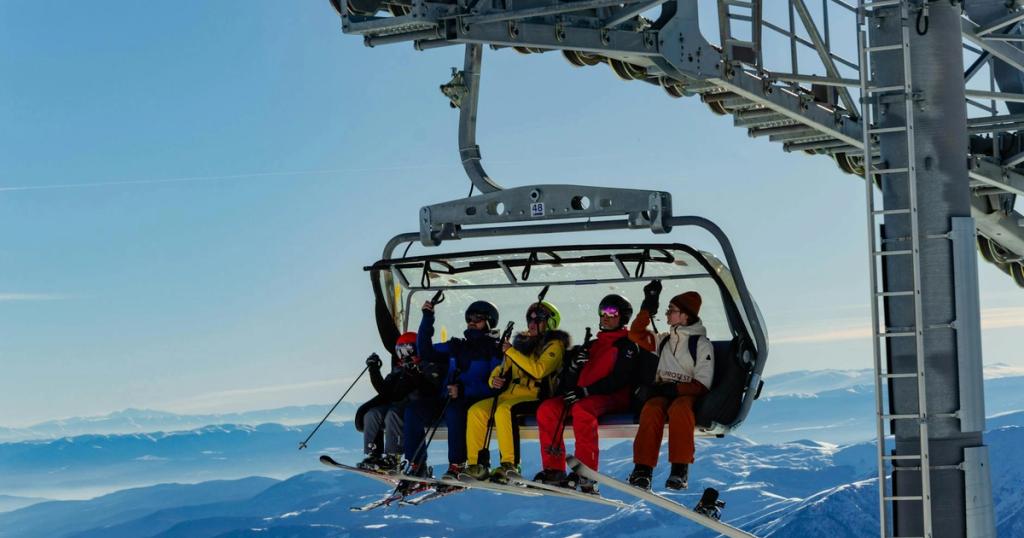 Group of skiers on a chairlift enjoying the winter scenery in Gudauri, Georgia.