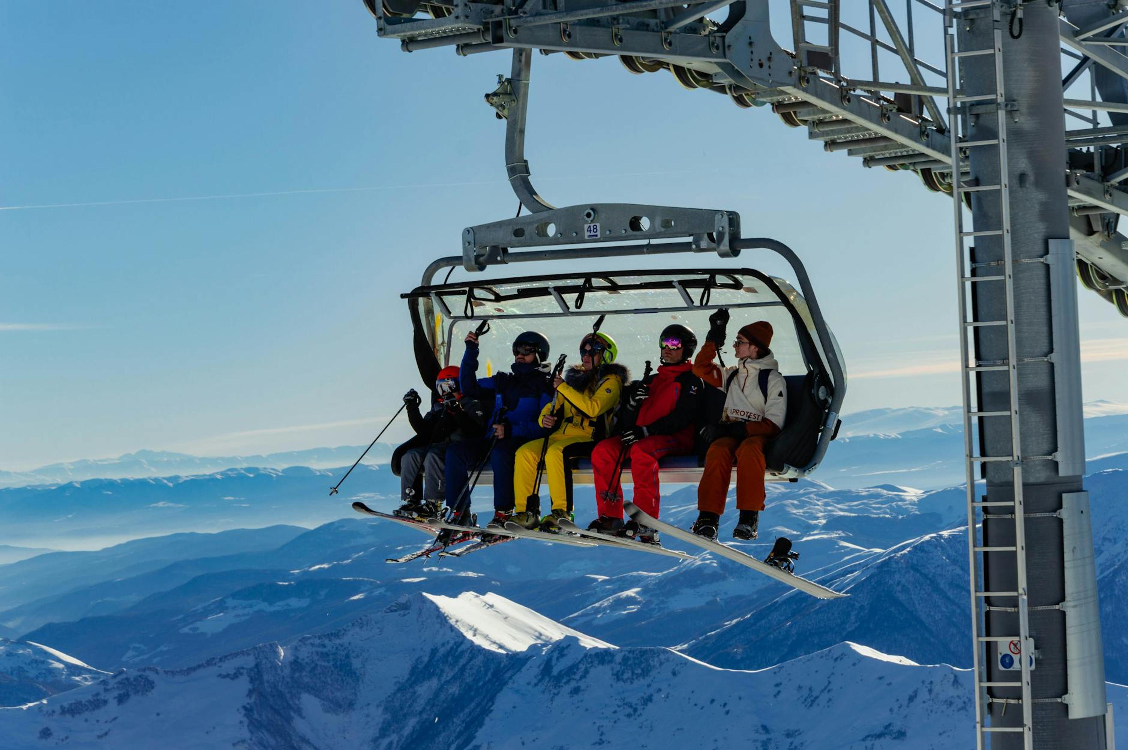 Group of skiers on a chairlift enjoying the winter scenery in Gudauri, Georgia.