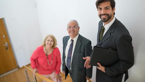 Realtor assists senior couple in a modern home setting. Ideal for real estate themes.