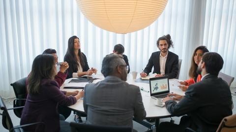 A diverse group of professionals discussing business strategy in a modern office setting.