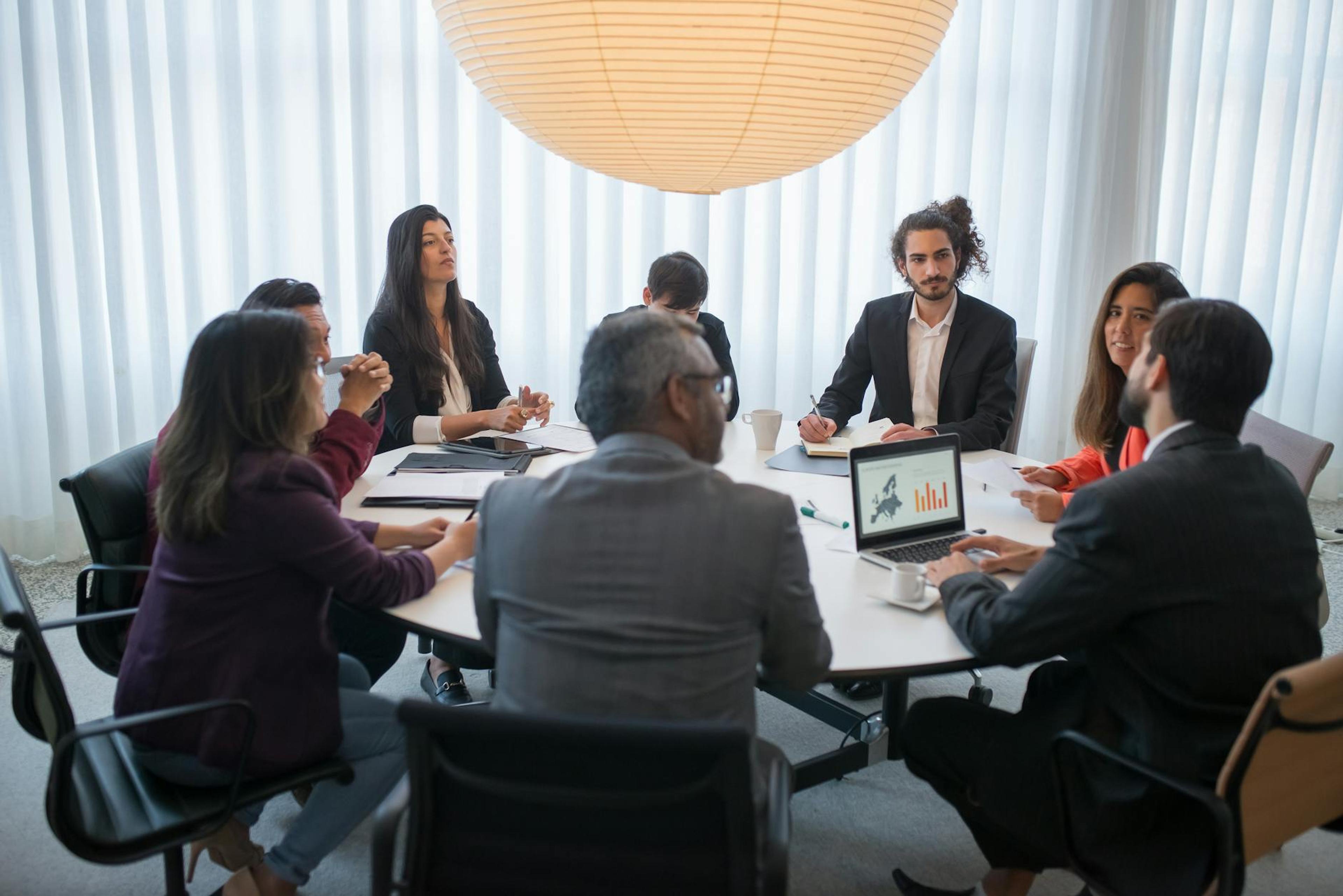 A diverse group of professionals discussing business strategy in a modern office setting.
