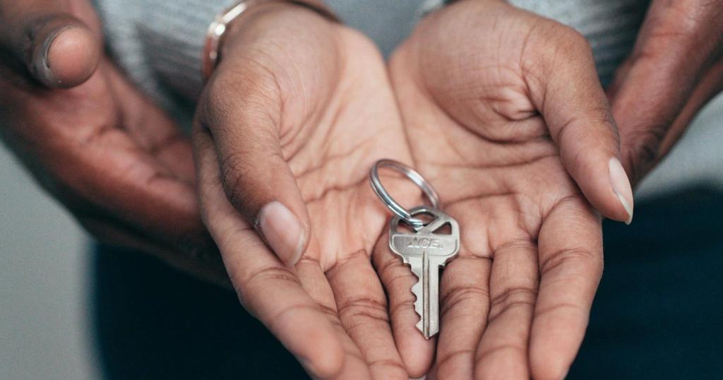 Close-up of hands holding a key, symbolizing homeownership, real estate, and property investment.
