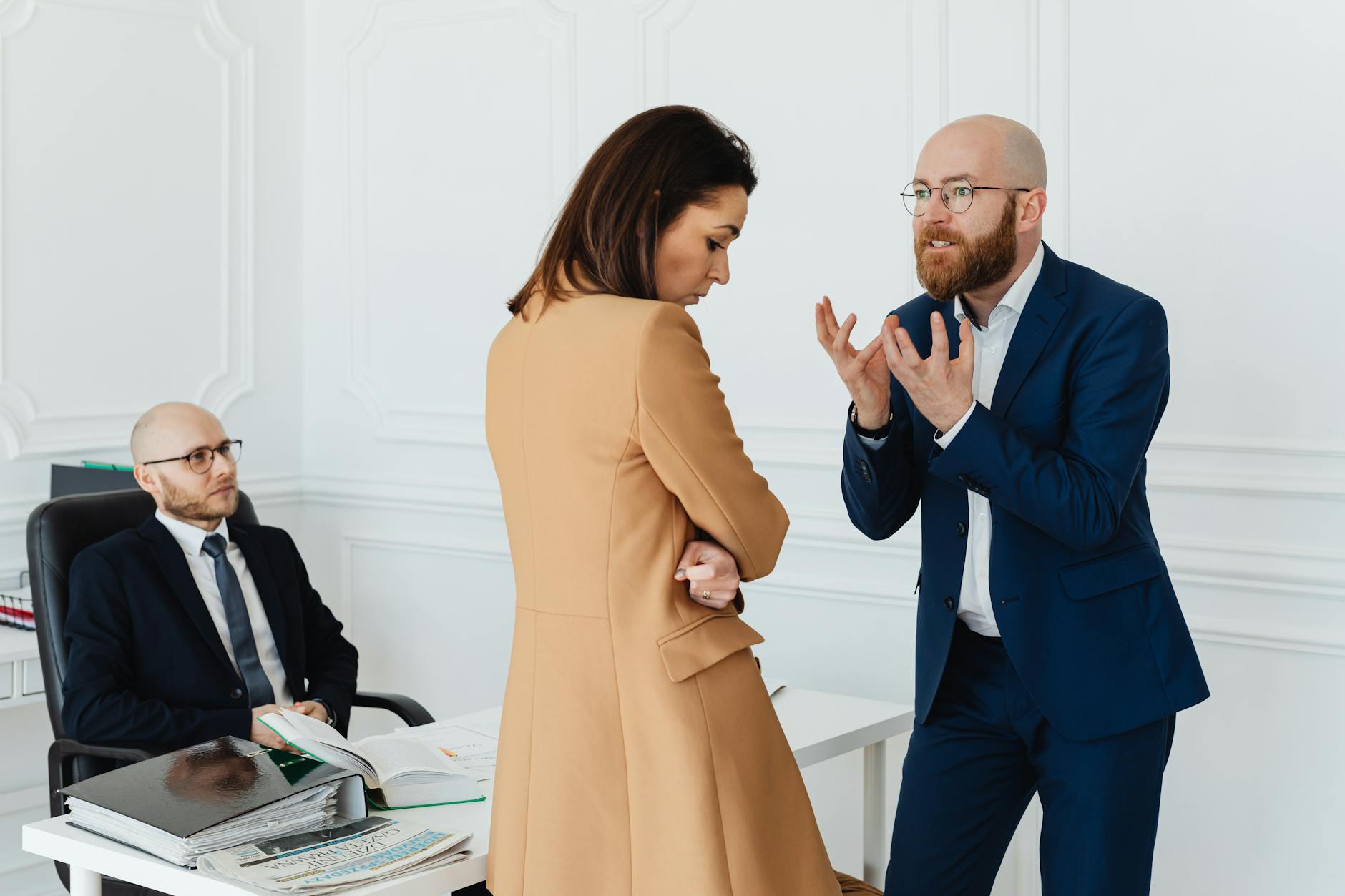 A group of business colleagues in a heated discussion at the office, showcasing workplace dynamics.