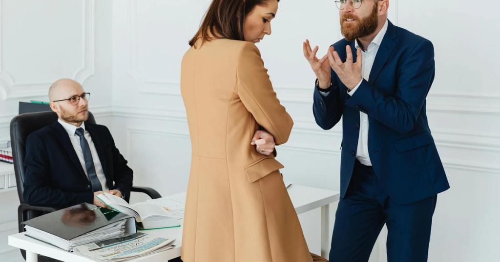 A group of business colleagues in a heated discussion at the office, showcasing workplace dynamics.