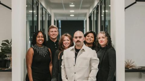 Diverse team of professionals posing in a modern office hallway in Greenville, SC.