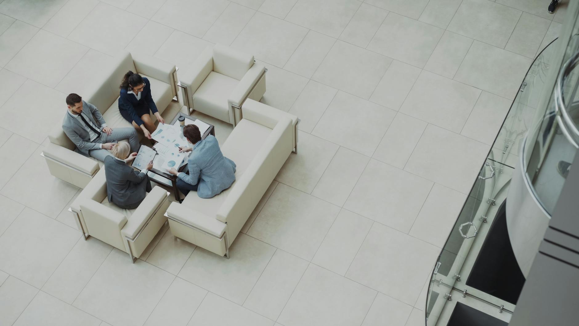 Aerial view of a business team discussing documents in a modern office setting.