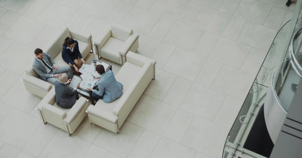 Aerial view of a business team discussing documents in a modern office setting.