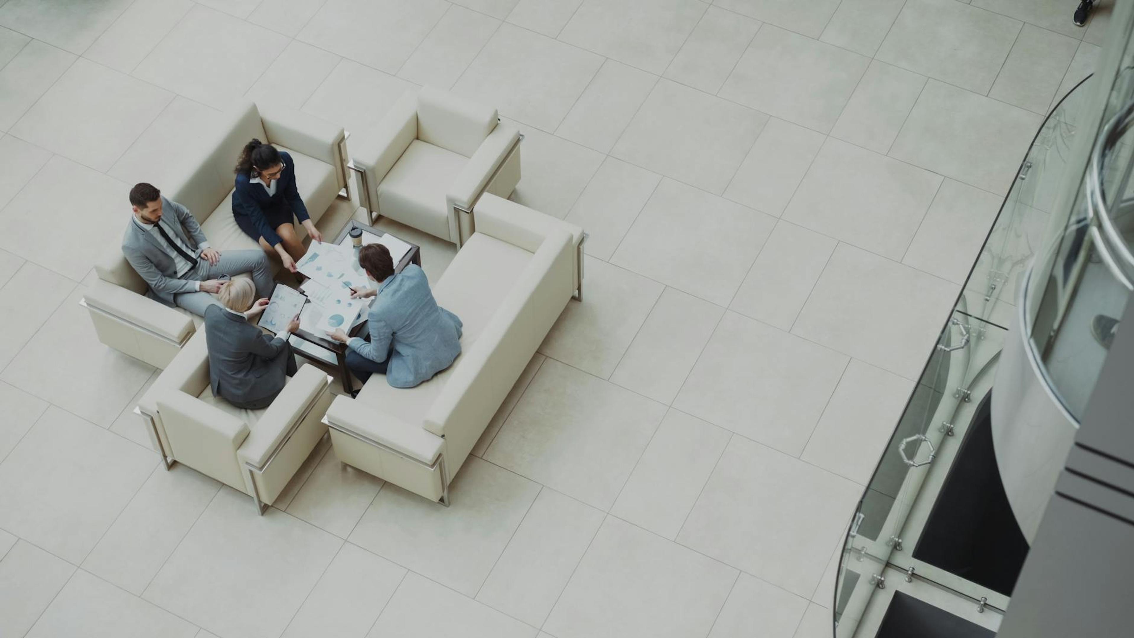 Aerial view of a business team discussing documents in a modern office setting.