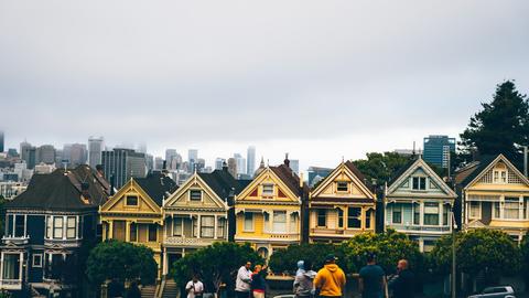 a group of people standing in front of a row of houses
