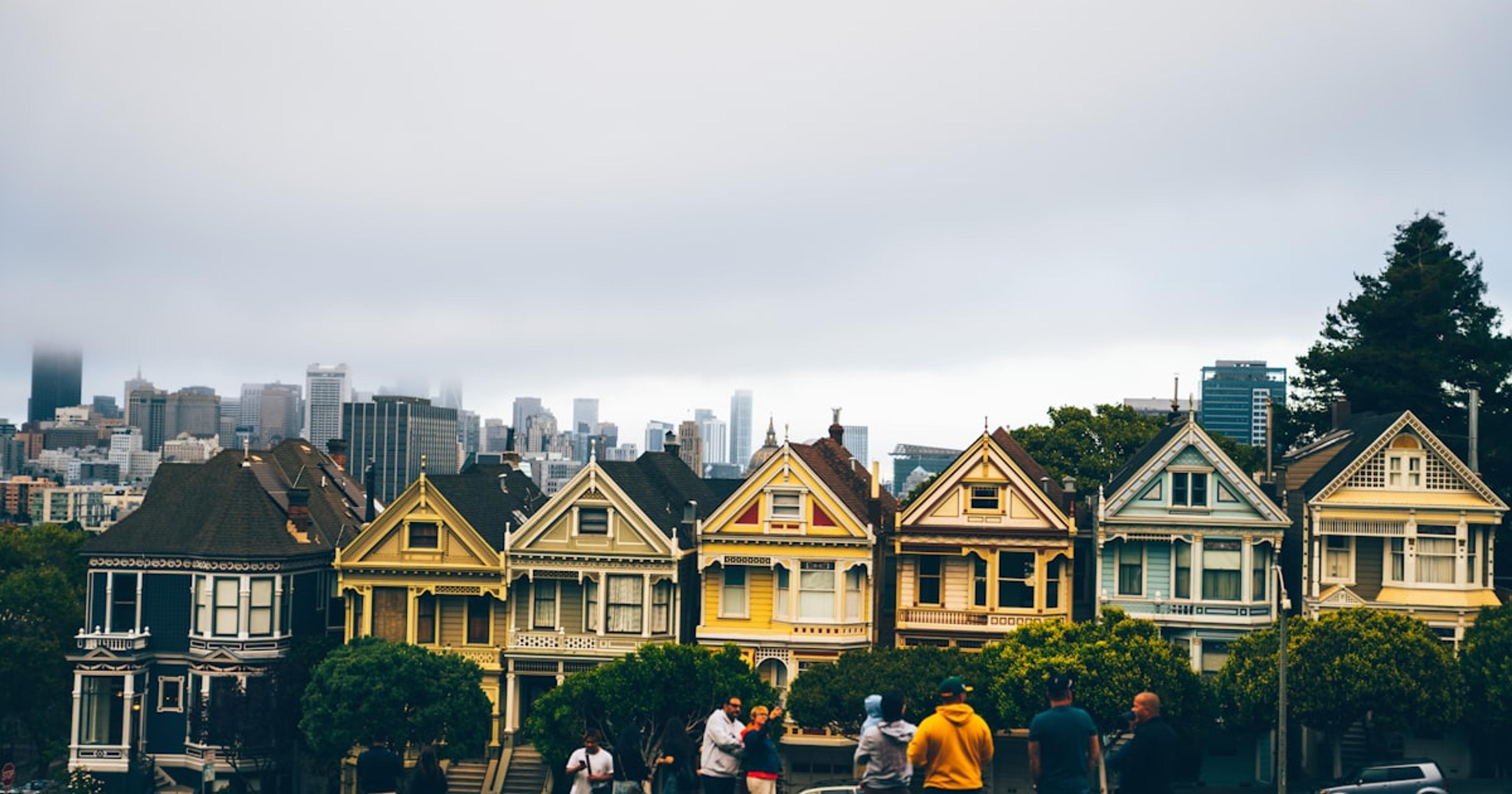 a group of people standing in front of a row of houses