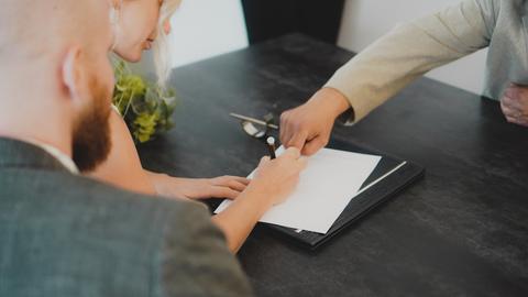 a woman showing a man something on a tablet