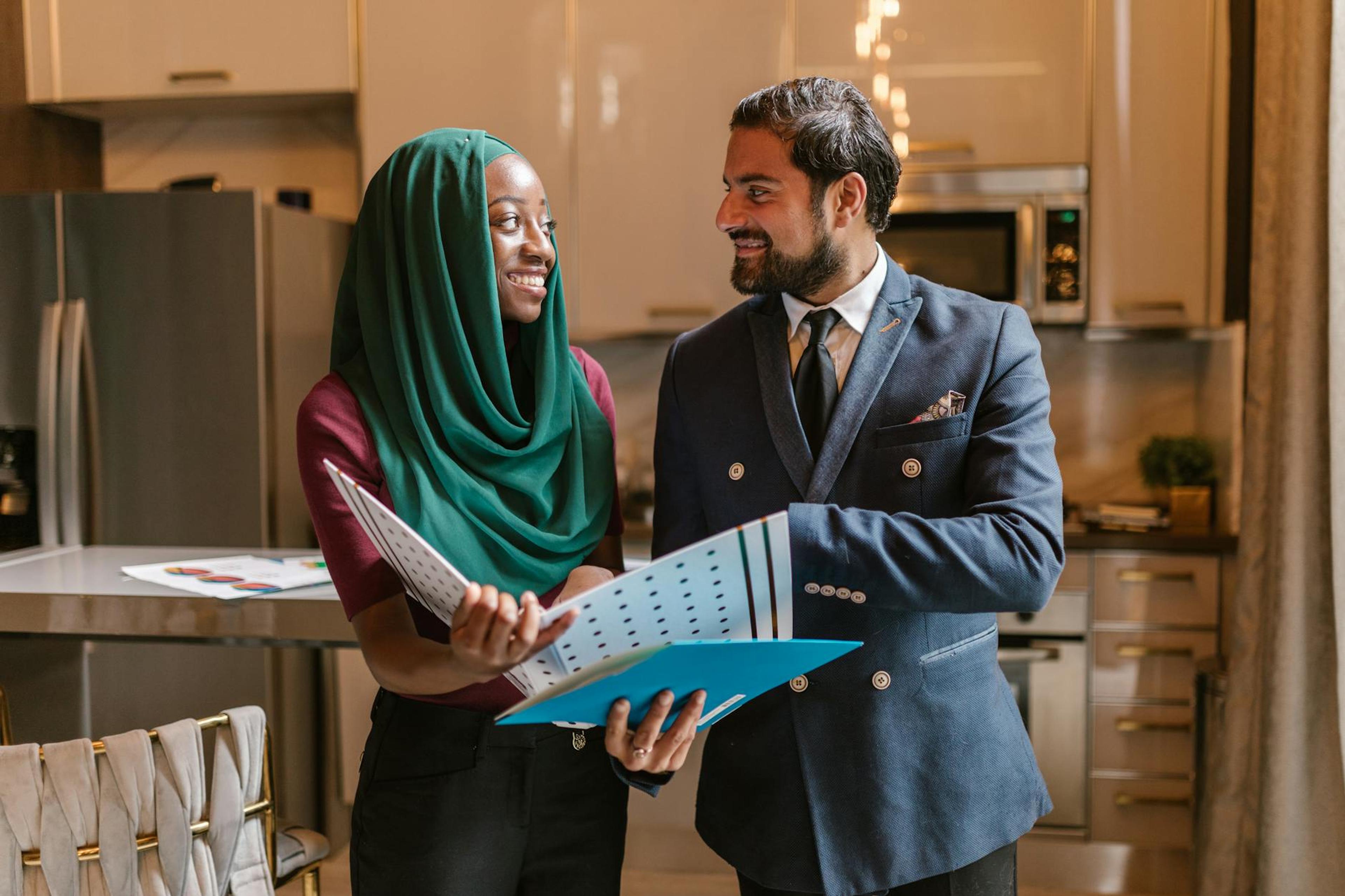 Smiling colleagues in a modern office discussing documents and business opportunities.
