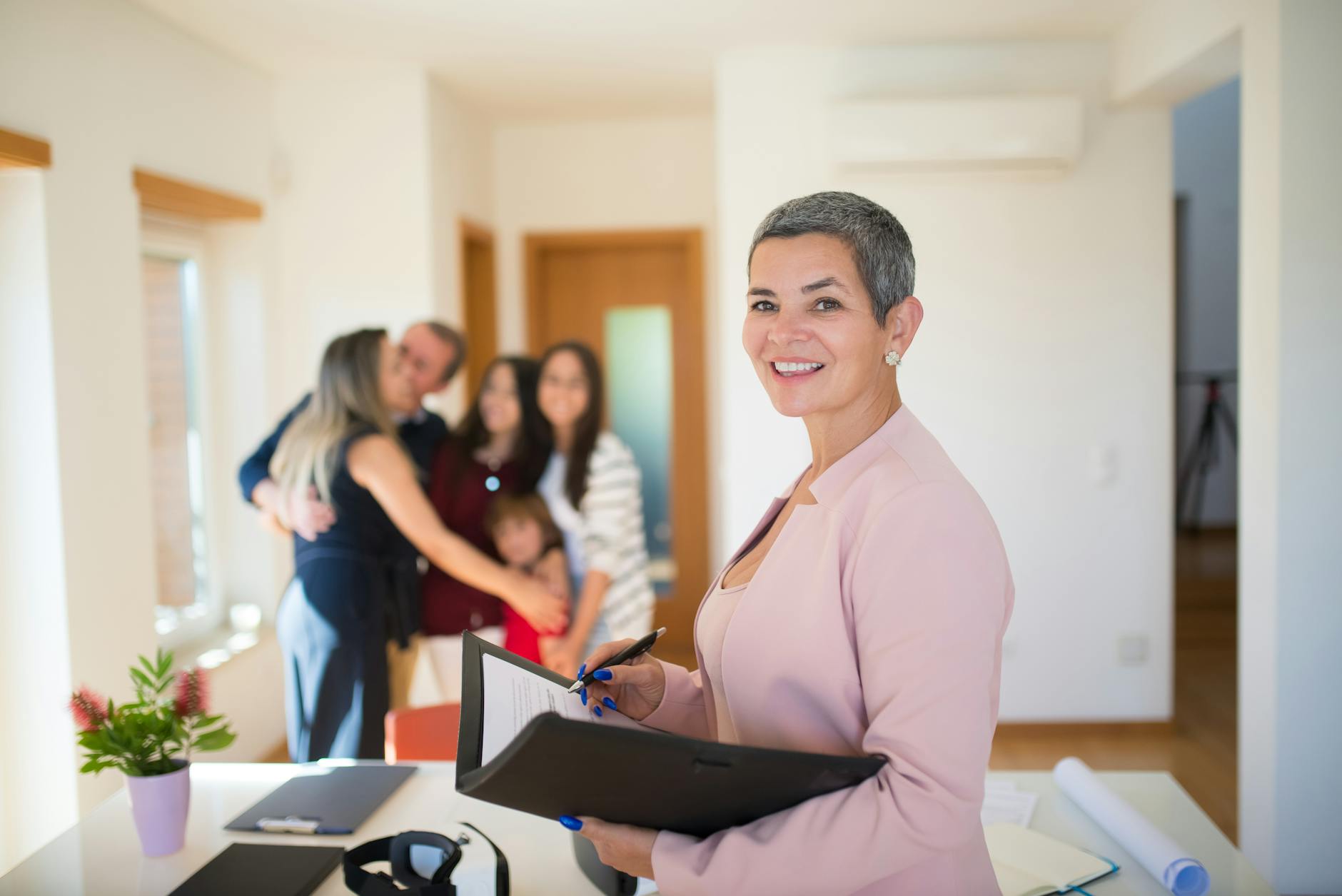 Confident real estate agent presents modern home to elated family, sealing the deal with a smile.