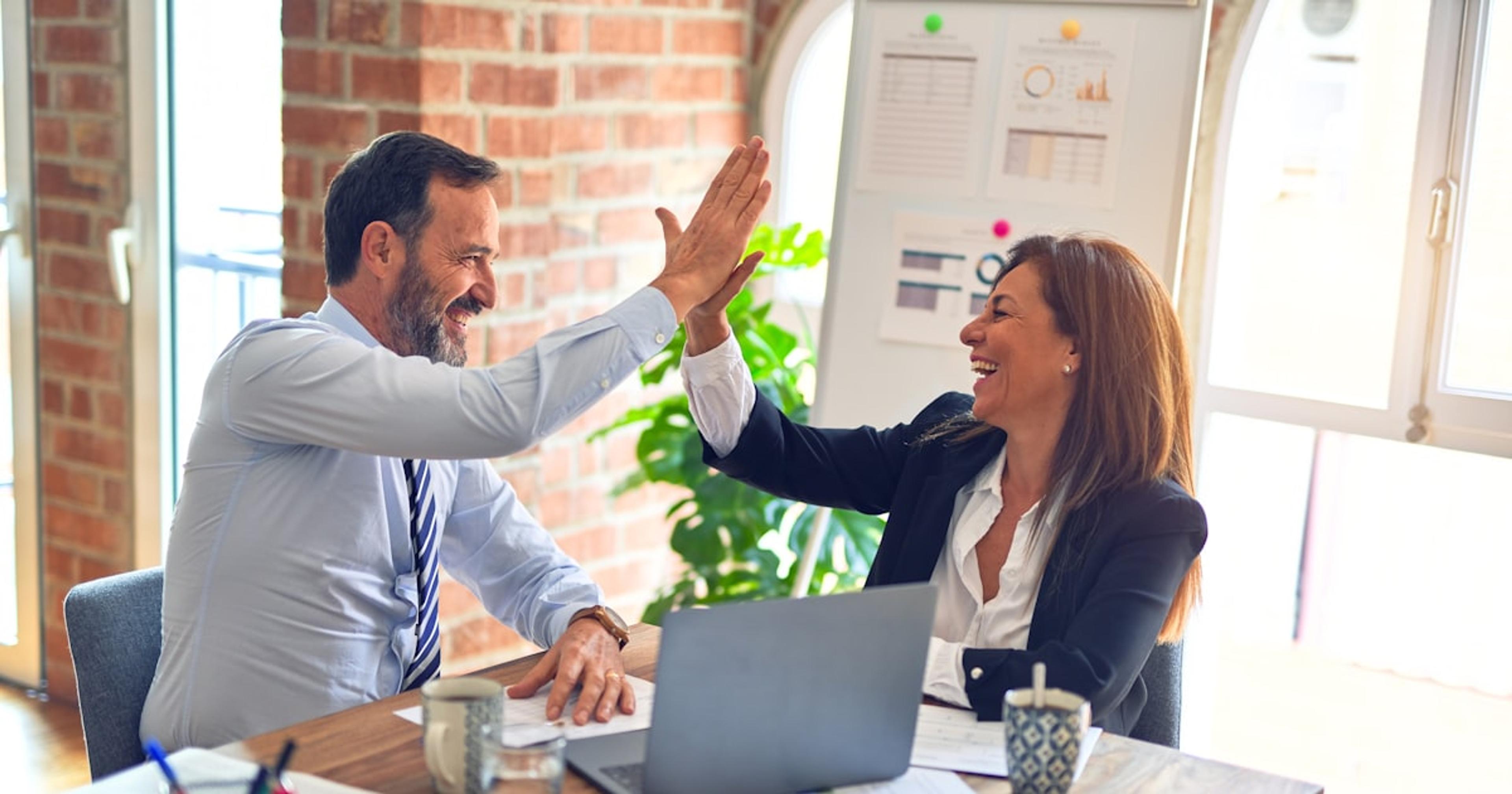man in white dress shirt sitting beside woman in black long sleeve shirt