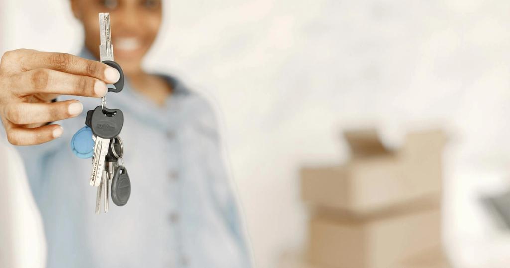 Close-up of a woman holding keys with a blurred background, symbolizing a new home or real estate concept.
