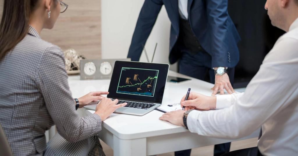 Professional team analyzing stock market trends on a laptop during a meeting.