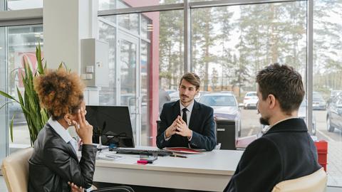 Three adults in a modern office setting having a professional business meeting.