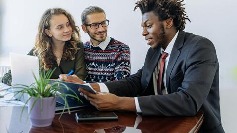A diverse group of professionals collaborating in an office meeting, showcasing teamwork and partnership.
