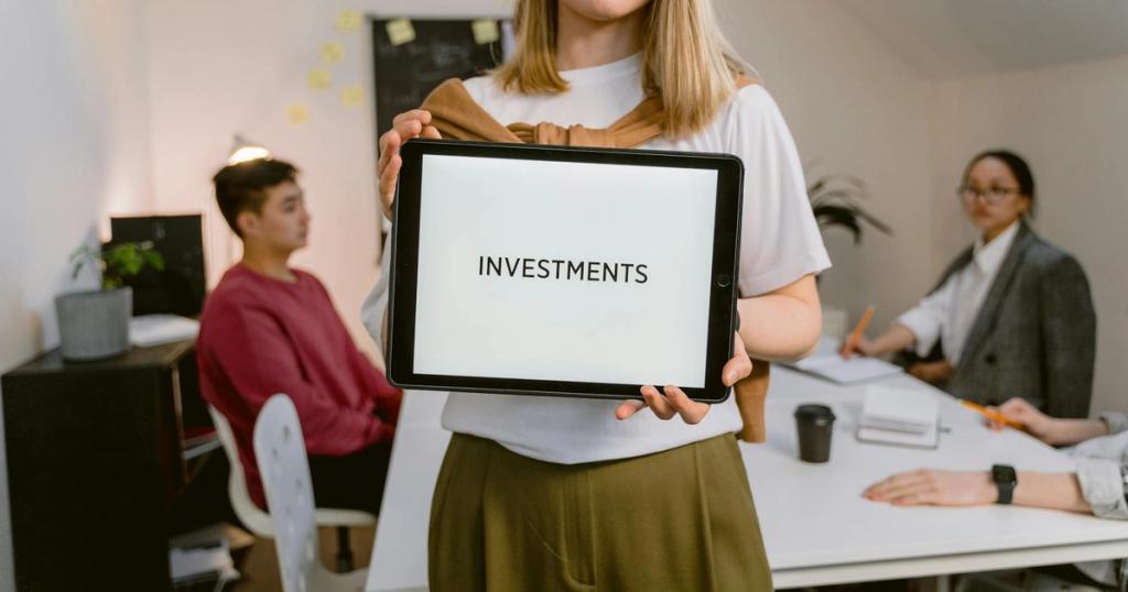 Young professional holding tablet in team meeting focused on investments.