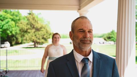 a man in a suit and tie standing next to a woman
