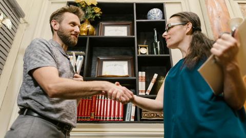 Professional handshake between a man and a woman in an office environment, symbolizing partnership.