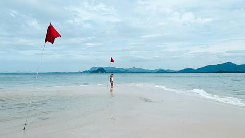 A person on a beach flying a kite