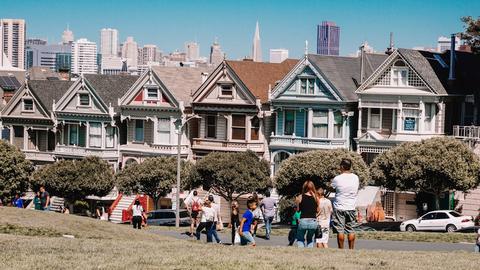 a group of people walking in front of a row of houses