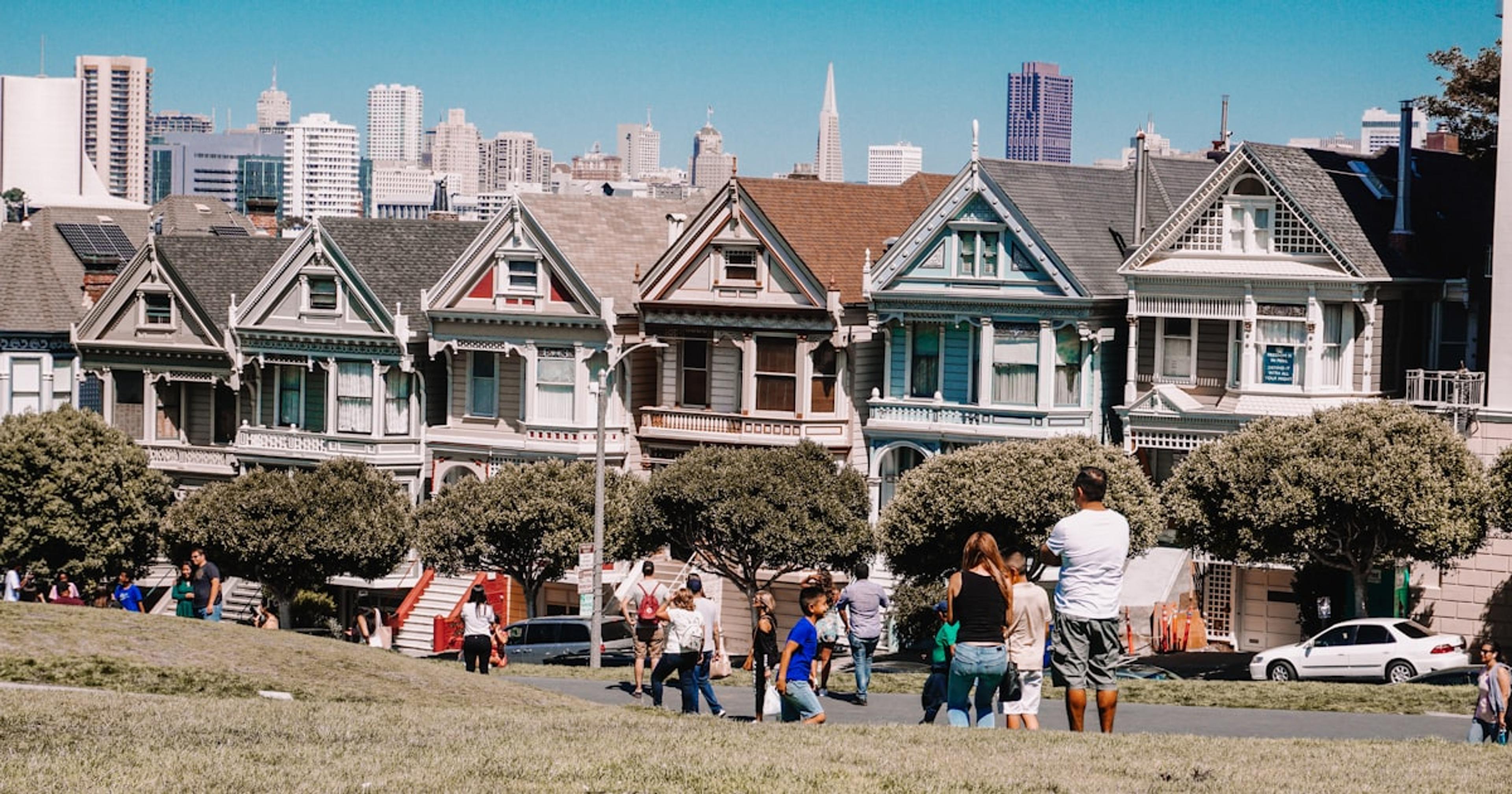 a group of people walking in front of a row of houses