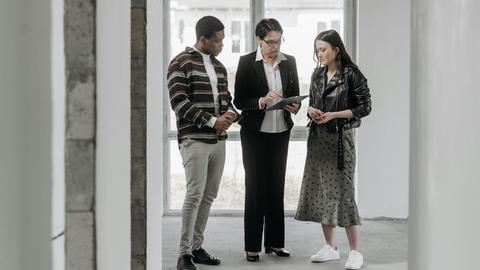 A real estate agent discusses property details with potential buyers during a house viewing.