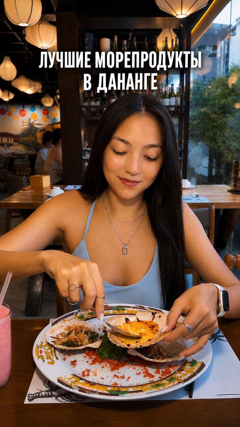 Amanda with a plate of baked scallops in a restaurant hung with lanterns