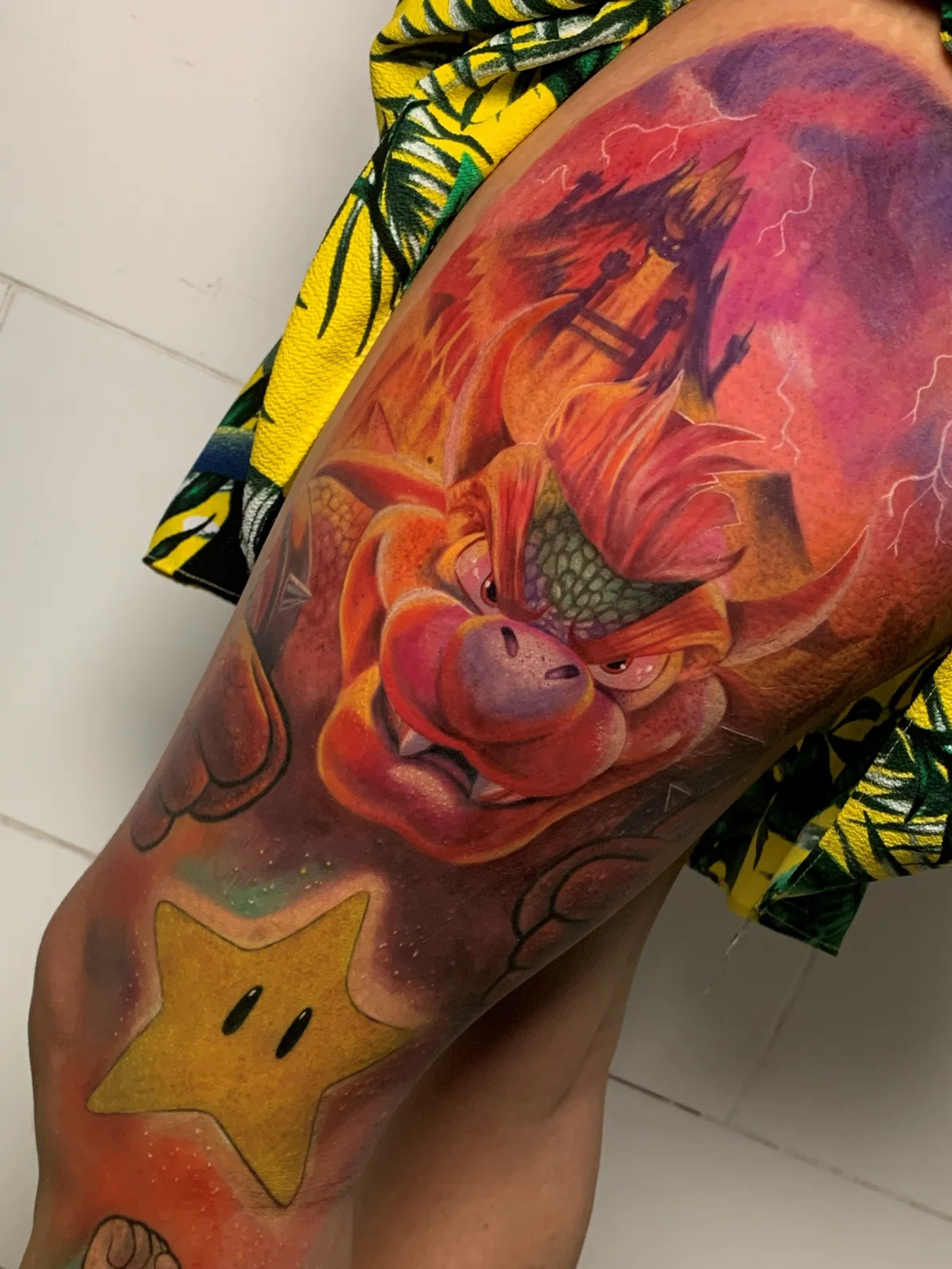 Tatuagem colorida de Dragon Ball com estrela do Mario na perna