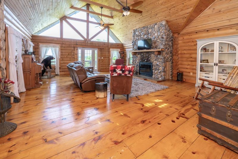 Main level family room with warm log walls and fireplace
